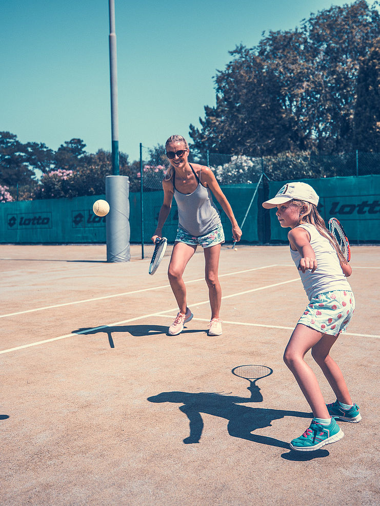 Mutter und Tochter beim Tennis spielen