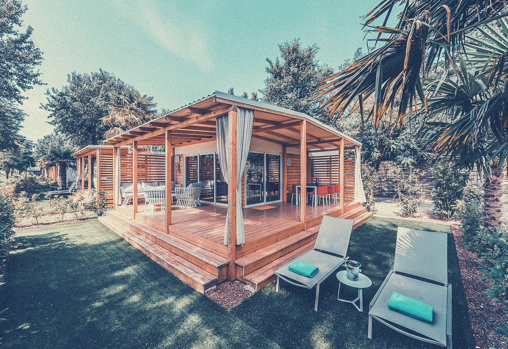 Sun loungers in the garden of a cottage of Resort Tenuta Primero in Grado