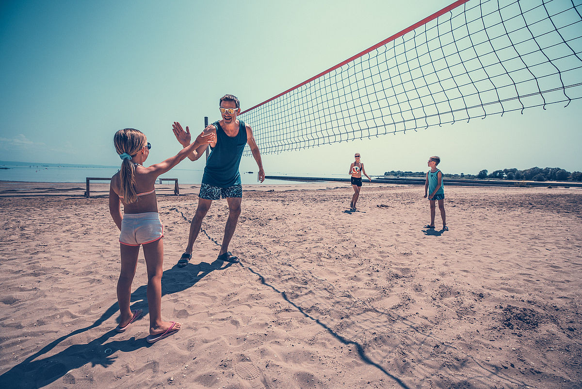 Vater und Tochter beim Beach Volley spielen