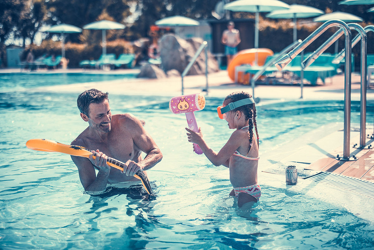 Vater und Tochter spielen im Pool