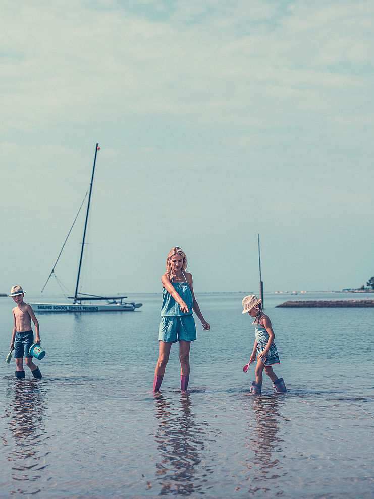 Mamma e figli cercano granchi con bassa marea