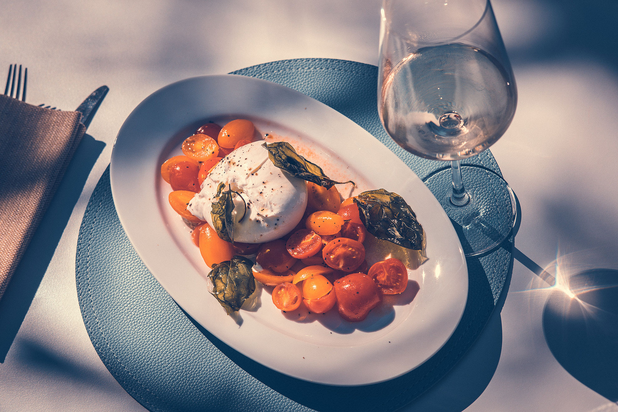 Mozzarella with tomatoes on plate and glass of wine